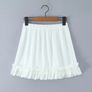 Detail van witte minirok met hoge taille, elastische tailleband en ruches aan zoom