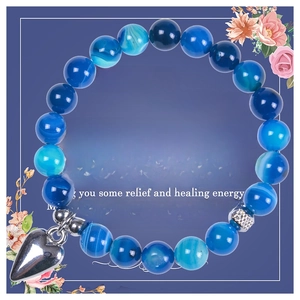 Detail of 8mm blue agate beads bracelet with a silver heart pendant and healing card