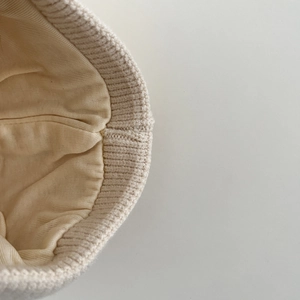 Detail of baby knit hat showing soft fabric lining and high-quality stitched edges