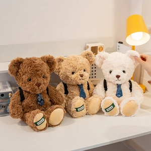 Three plush teddy bears in brown and white colors with blue ties on a cozy desk
