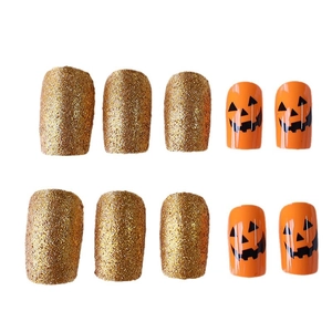 Unghie finte Halloween con zucche arancioni e finitura con glitter dorati brillanti