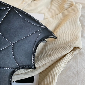 Nahaufnahme Detail der schwarzen PU Leder Fledermausflügel Handtasche mit Kontrastnähten.
