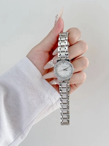 Detail view of a luxury ladies watch with rhinestone bezel and silver metal strap