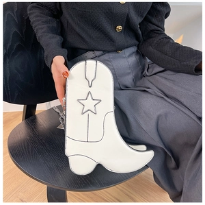 Gros plan d'un sac à bandoulière blanc créatif en forme de botte avec étoile