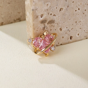 Pink heart-shaped zircon pendant with golden frame on textured stone background