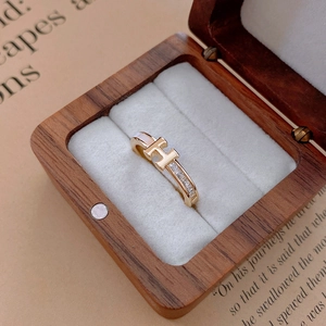 Detailed macro view of 18k gold-plated H-letter ring with white enamel and zircons