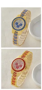 Close-up of luxury gold-plated quartz watches with blue and red crystals on dial