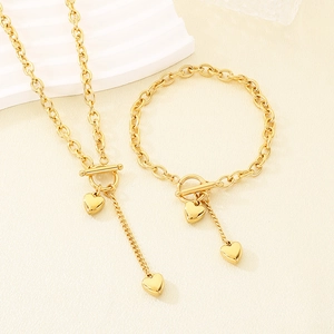 Goldenes Herzanhänger-Halsketten- und Armband-Set mit OT-Knebelverschluss auf Stoff