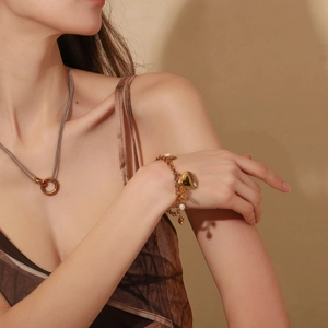 Elegant 18K gold plated heart pendant bracelet and necklace set worn by a model