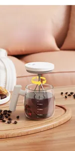 Detail view of electric self-stirring glass cup with clear scale marks on wooden tray
