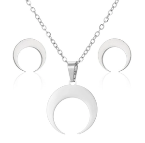 Detailed view of silver crescent moon necklace and earrings set with polished finish