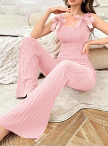 Ensemble homewear rose deux pièces avec caraco à nœud et pantalon côtelé dans une chambre