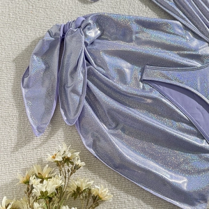 Détail d'un bas de bikini violet brillant avec noeud latéral et texture métallisée chic