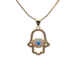Gold Hamsa Hand necklace with crystal pavé and blue evil eye pendant on white background