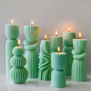 Artistic peppermint green striped cylindrical and knot scented candles on gray background