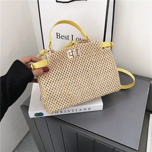 Detail of hand-woven straw bag with yellow leather strap and golden turn-lock closure
