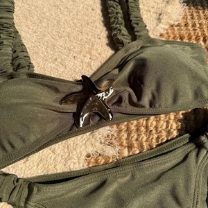 Close-up of olive green bikini with smocked straps and metallic starfish detail
