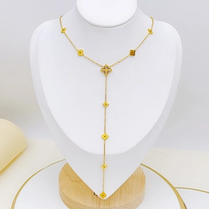 Elegant gold-tone Y-shape necklace with clover pendants on a jewelry display stand