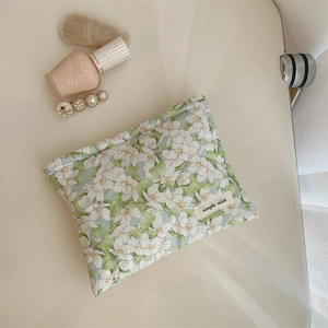 Detail view of cotton floral makeup pouch with simple wish label and soft padding