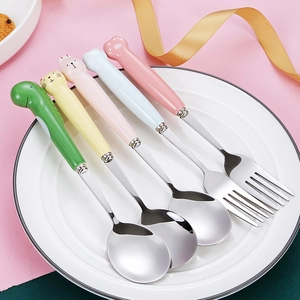 Close-up of pastel animal paw handle spoons and forks on a white plate