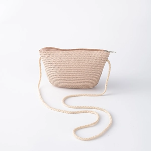 Détail d'un sac en paille beige pour enfant avec fermeture éclair et bandoulière
