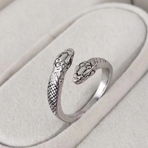Macro shot of vintage silver snake ring showing detailed scales and dual serpent heads