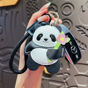 Luxurious leather panda keychain with pink flower and black woven lanyard on a car key