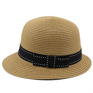 Detail of straw hat texture with black ribbon and bow decoration on white background
