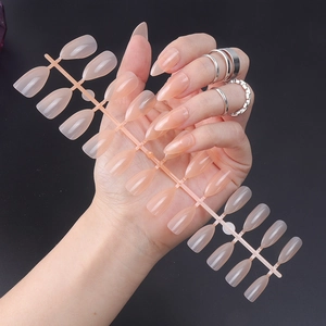 Close-up of translucent nude pink press-on nails set on hands with elegant rings