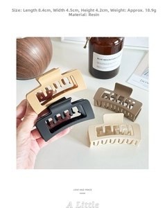 Detail of square resin hair claws showing matte finish and hollowed-out cross tooth design