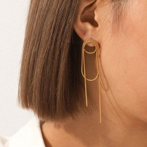 Nahaufnahme eleganter goldener Quastenohrringe, getragen von einem Modell für Stil