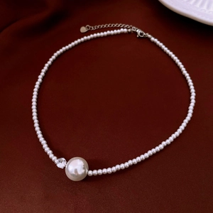Detailed close-up of French luxury pearl necklace with zircon pendant on velvet cloth