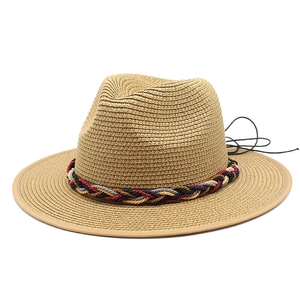 Dettaglio dell'intreccio di un cappello di paglia marrone chiaro con fascia intrecciata colorata