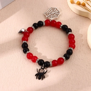 Detail of beaded Halloween bracelet with silver spiderweb, black spider, and heart charms