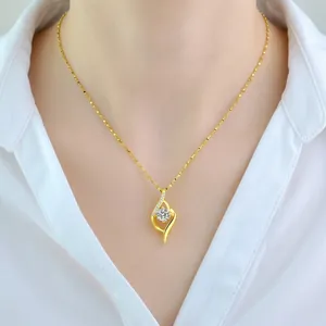 Elegant gold leaf pendant necklace with brilliant main stone and diamond accents on model