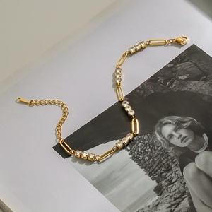 Macro detail of gold-plated stainless steel tennis bracelet with white cubic zirconia crystals