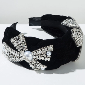 Détail d'un serre-tête en velours noir tressé avec nœuds en strass et perles nacrées