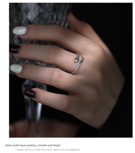 Detailed view of silver snake ring featuring green gemstone eyes and textured scales