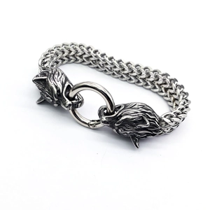 Macro shot of stainless steel viking bracelet with intricate wolf head charms and mesh chain