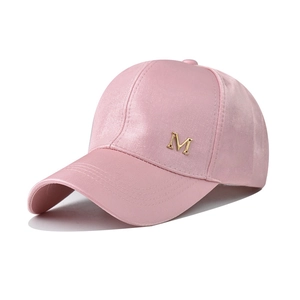 Dettaglio del cappellino da baseball in velluto rosa con emblema M in metallo dorato