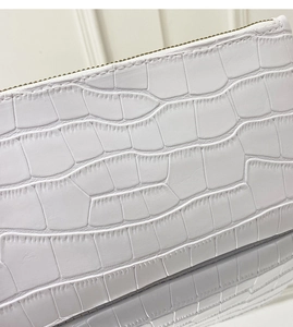 Close-up of white crocodile pattern leather texture and high-quality metal zipper detail