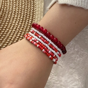 Bohemian seed bead bracelet set with multi-layer red and pink beads on a wrist