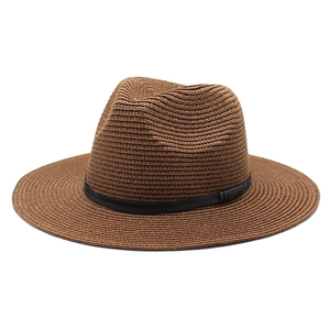 Detailed close-up of brown straw Panama hat with black leather band and woven texture