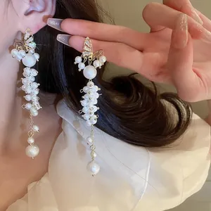 Detail of long butterfly earrings with cascading pearls and crystal fringe on model