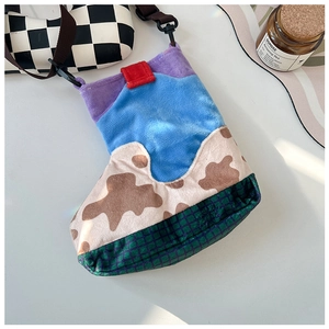 Detail of colorful patchwork nylon crossbody bag with cow print and plaid textures