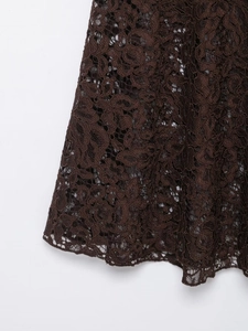 Detail of dark brown floral lace fabric showing intricate patterns and texture
