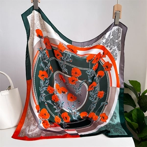 Detailed drape of silk square scarf featuring vibrant red poppy floral and geometric patterns