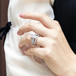 Macro detail of silver marquise cut zircon ring with pavé diamond setting on finger