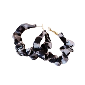 Hoop earrings with leopard print fabric wrap and golden posts on white background