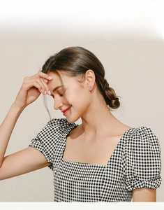Model wearing silver infinity symbol stud earrings with turquoise and micro-inlay zircon